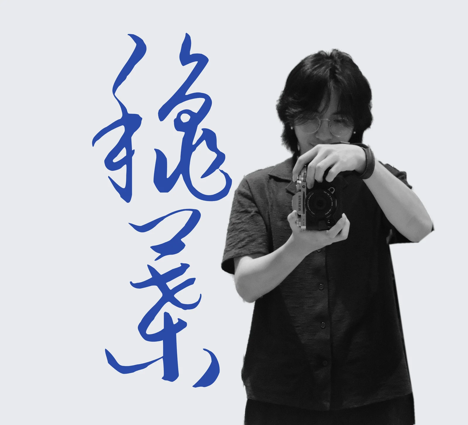 Andy Ou holding a camera, with 秋叶 brushed in blue beside him